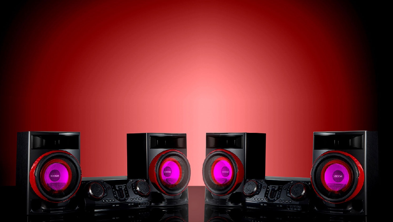 LG XBOOM CL87 - Sistema completo sobre fundo vermelho com iluminação RGB nos alto-falantes