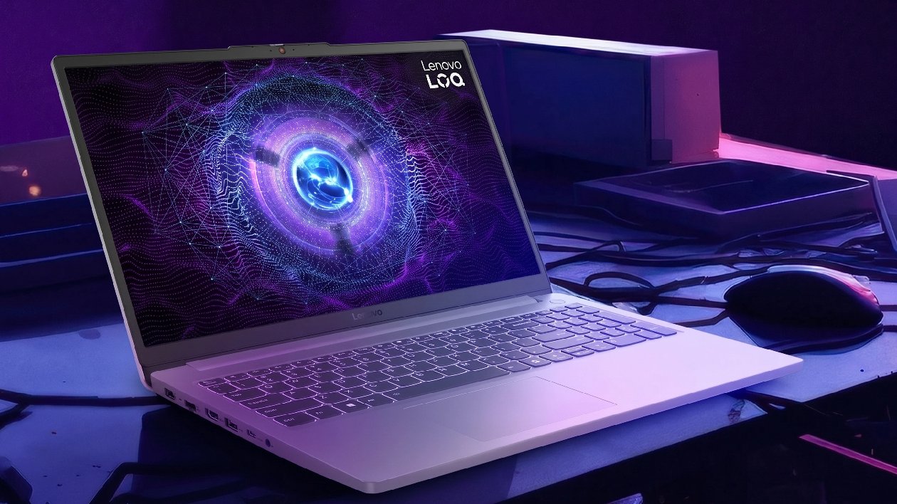Notebook gamer Lenovo LOQ 15IAX9E Luna Grey em &acirc;ngulo diagonal com mouse e ilumina&ccedil;&atilde;o roxa e azul mostrando tela com gr&aacute;fico futurista e teclado retroiluminado