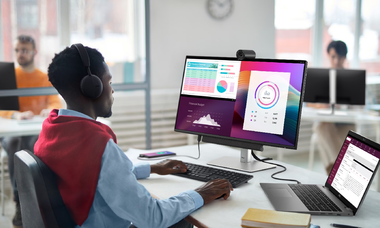 Monitor Dell P2725H Pro Plus em ambiente de escritorio com pessoas trabalhando e cabos conectados