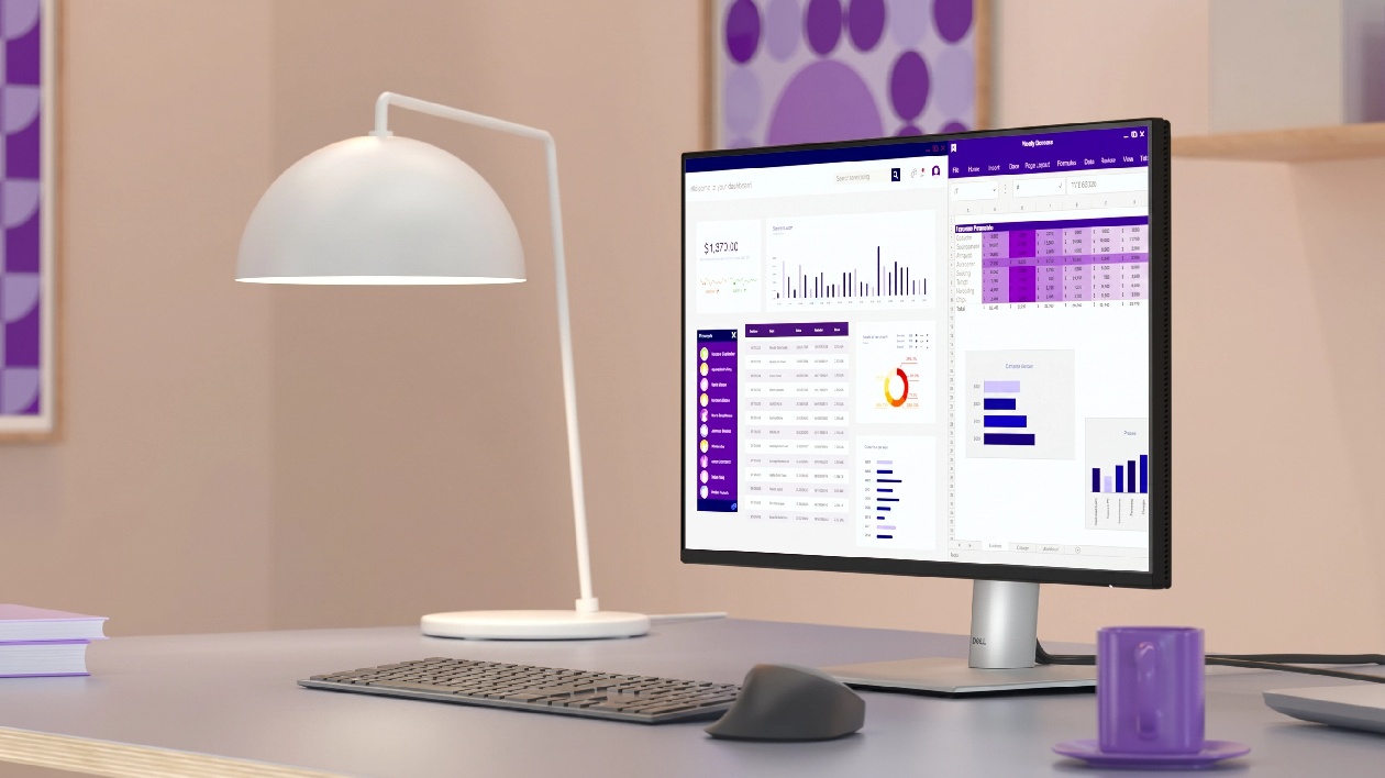 Monitor Dell P2425HE Pro Plus em ambiente de escrit&oacute;rio com teclado mouse e lumin&aacute;ria exibindo dashboard na tela