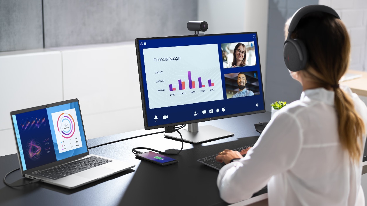 Setup com monitor Dell P2725QE Pro Plus 4K em videoconferencia com laptop e smartphone carregando via USB-C 90W dock station