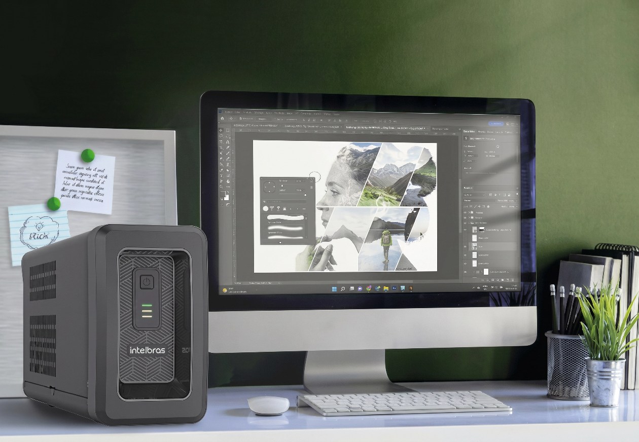 Nobreak Intelbras ATTIV SENO 1800VA posicionado em mesa de escrit&oacute;rio ao lado de monitor, teclado e mouse, protegendo equipamentos de trabalho