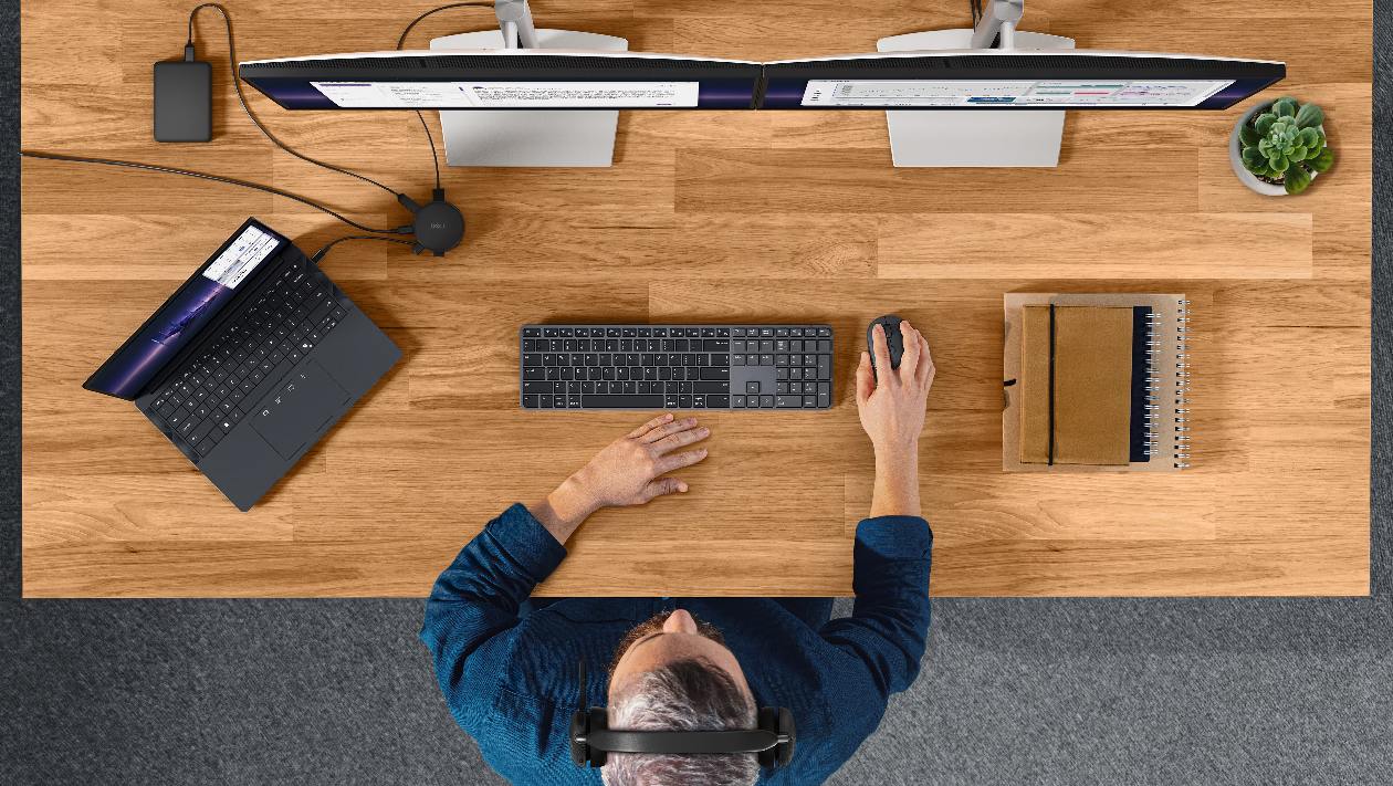 Vista aérea de estação de trabalho com dual-monitor conectado ao Dell Pro DA326 com teclado mouse e headset