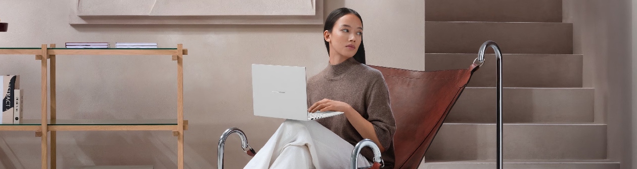 ASUS Zenbook S 14 sendo usado no colo em ambiente residencial/corporativo