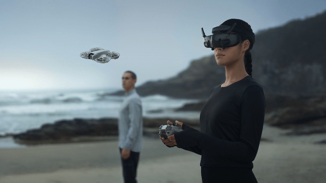 Piloto na praia utilizando óculos FPV DJI Goggles e controle DJI RC Motion 3 para pilotagem imersiva