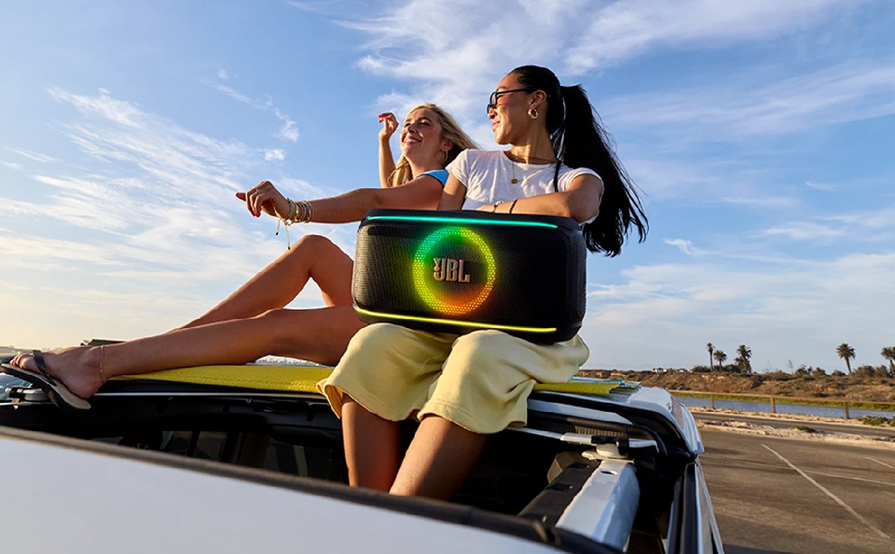 Caixa de som JBL PartyBox On-The-Go 2 em ambiente de festa com iluminação