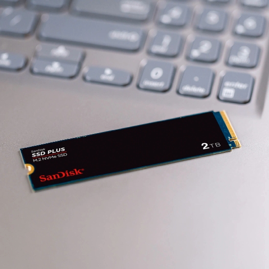 Close-up do SSD M.2 NVMe SanDisk SSD PLUS 2TB sobre um notebook